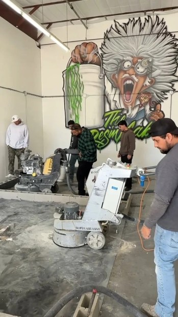 Crew grinding a slab under The Resin Lab mad-scientist mural in Tracy, CA
